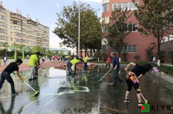 黨總支書(shū)記王炳林帶領(lǐng)大家清洗塑膠運(yùn)動(dòng)場(chǎng)的場(chǎng)景